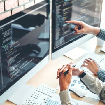 Dual computer screens with code on them